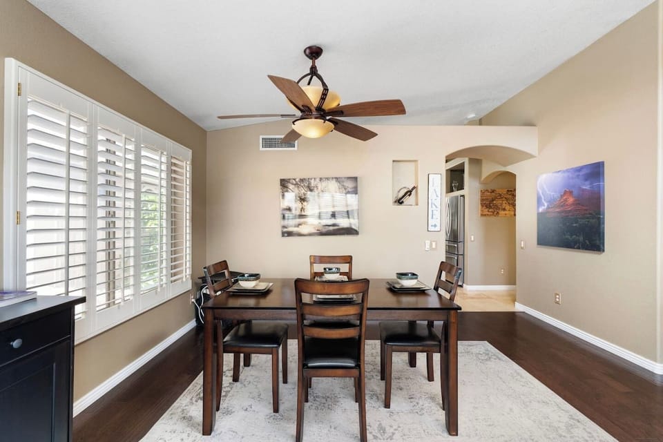 The dining area is bathed in natural light through plantation shutters, setting a warm and relaxed mood for every meal — whether it's a quick breakfast or a leisurely dinner.