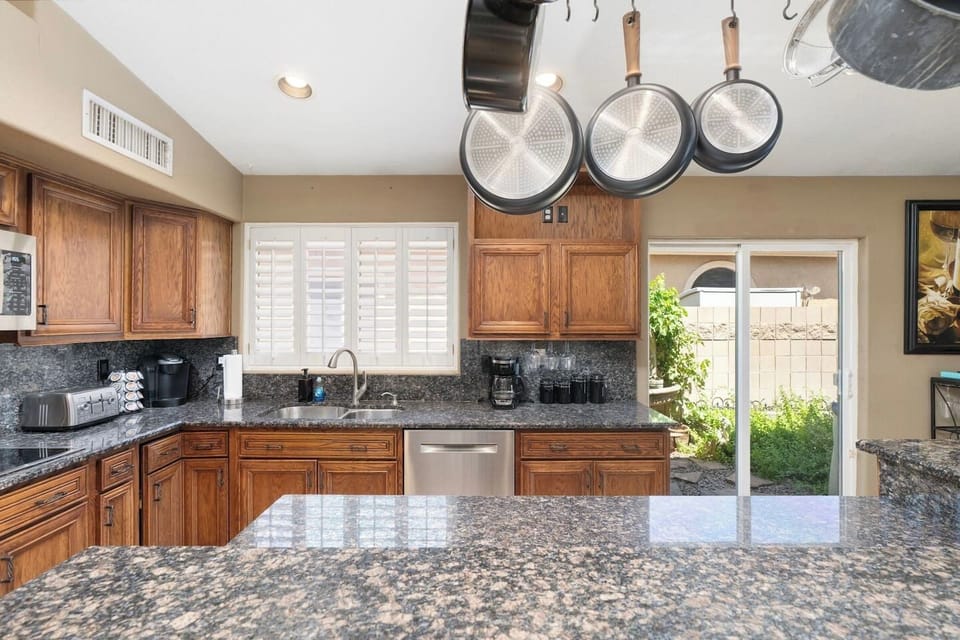 Wide granite countertops and a full cookware set give you everything you need to whip up a feast, with natural light streaming through the plantation shutters.