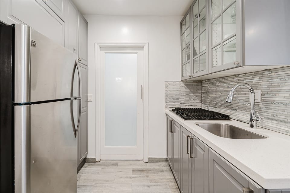 Fully equipped kitchen with modern finishes, cookware, and everything needed for preparing meals, seamlessly connected to the living and dining areas. (Gas stove is not operational- a 3-burner stove is available)