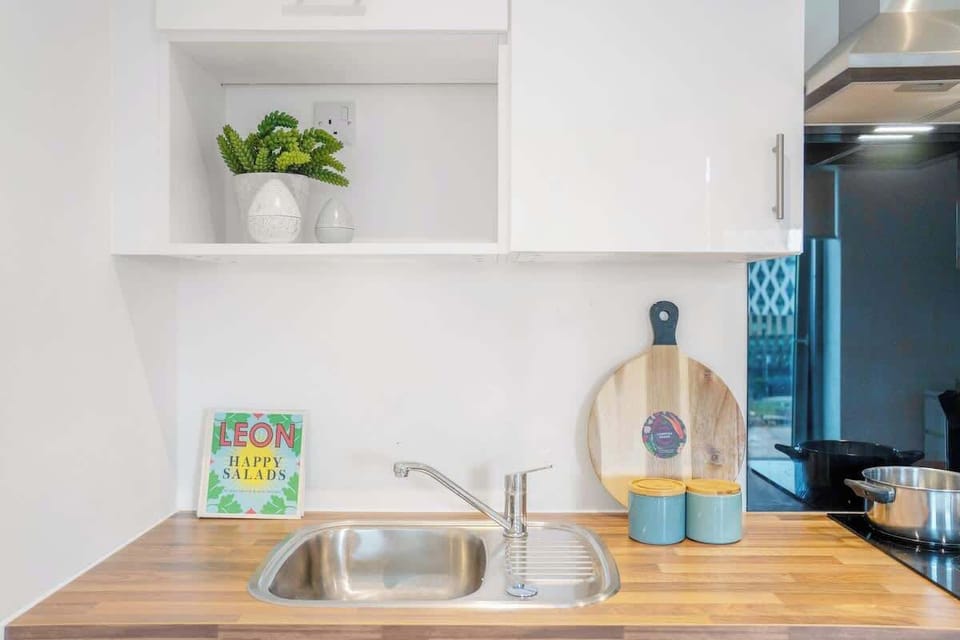 Located within the main open-plan area of the studio apartment, the kitchen is fully equipped with an oven, fridge, cookware, and utensils, providing a practical space for everyday meal preparation.