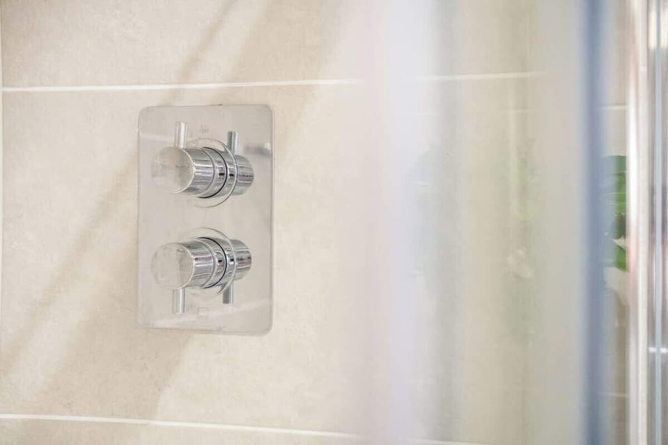 This studio apartment benefits from a well-appointed bathroom with an overhead shower, sink, and toilet. Thoughtfully designed, it offers a functional space to refresh and unwind.