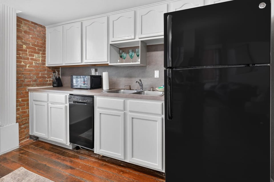 Well-equipped kitchen with brick and modern appliances.