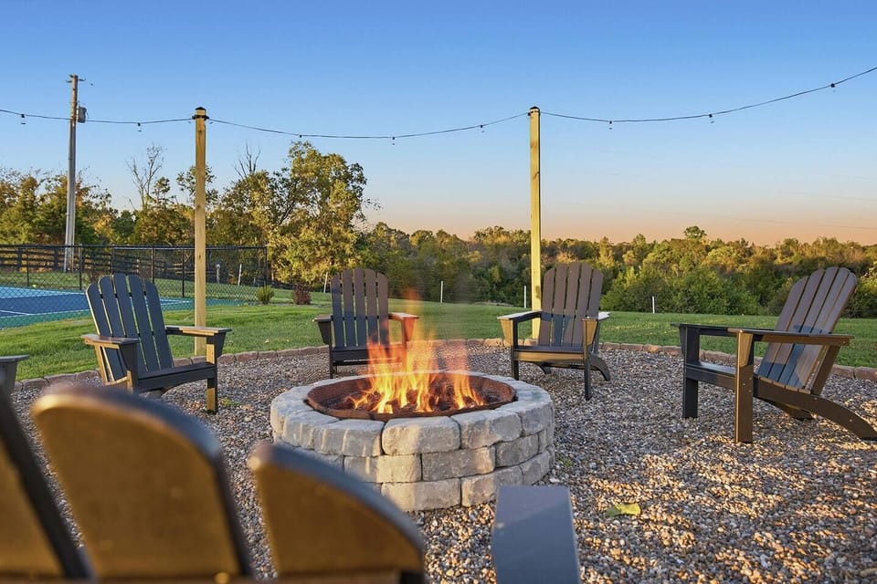 The cozy backyard oasis features a 6-person spa hot tub, dining table, gas fire table, fire pit with party lights (plenty of fire wood provided), and a pickleball court (paddles and balls provided). Not to mention views of the beautiful horses!