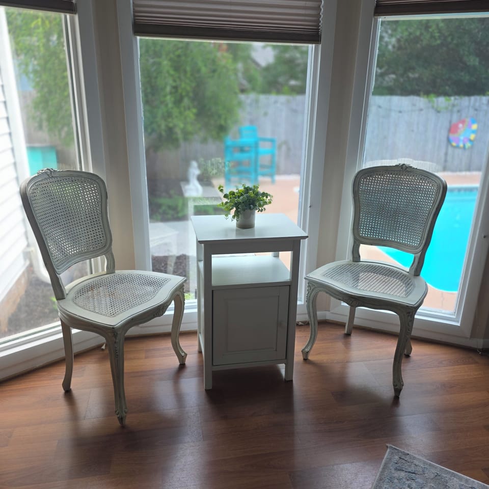 Bay window seating for 2 overlooking the pool and flower garden.