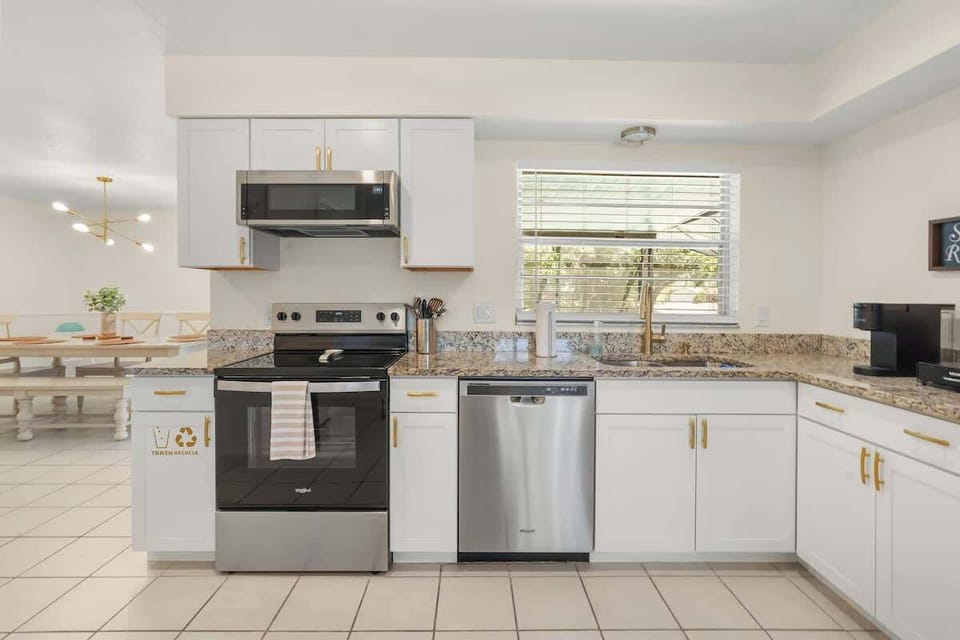 Fully equipped modern kitchen with high-end appliances, cookware, spices, oils, and family dining essentials plus convenient trash and recycling stations to make extended stays, team trips, and Disney vacations comfortable, easy, and stress-free.