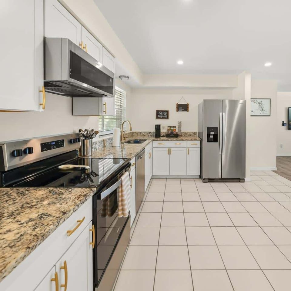 Spacious fully stocked kitchen with modern appliances, large prep areas, and a premium coffee bar featuring drip coffee, Keurig, coffee selections, teas, creamers, and cooking essentials perfect for families, groups, and tournament travelers toDisney
