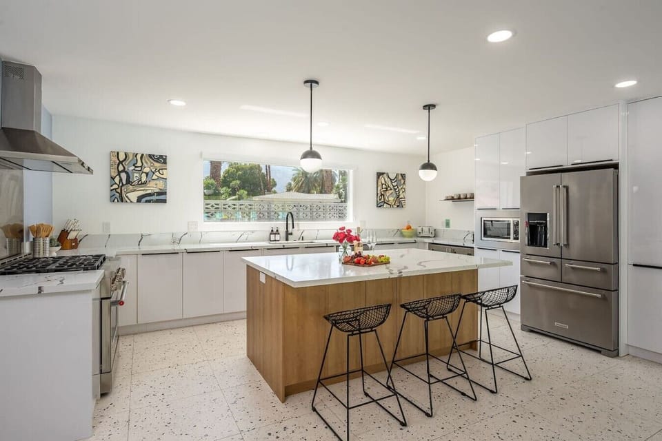 Fully stocked kitchen with stainless steel appliances and 3 bar stools