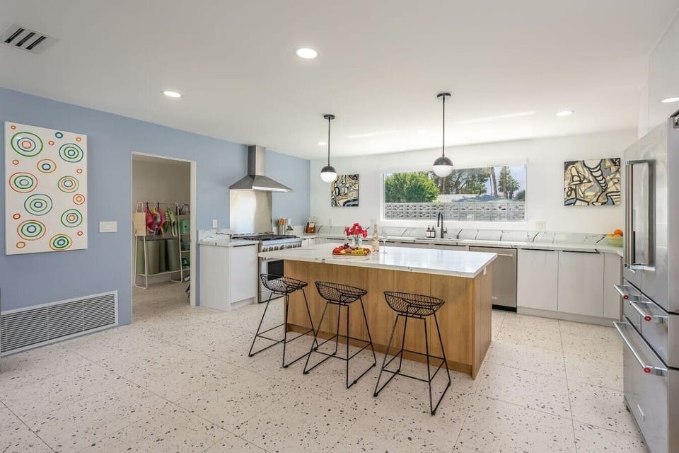 Fully stocked kitchen with stainless steel appliances and 3 bar stools