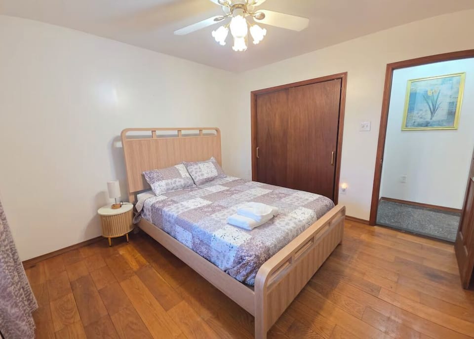 Bright, cozy bedroom with wood floors, ceiling fan, and spacious closet