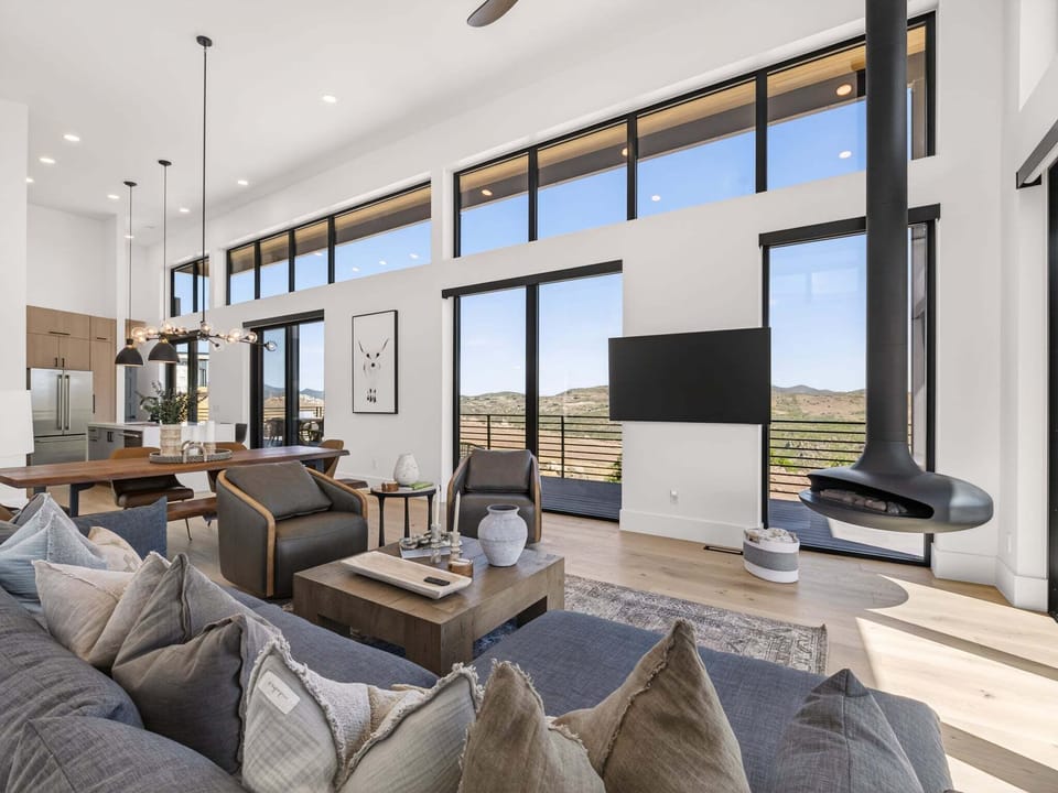 A suspended teardrop fireplace is the cornerstone of the expansive views through massive windows in the living room of Nordic Haven