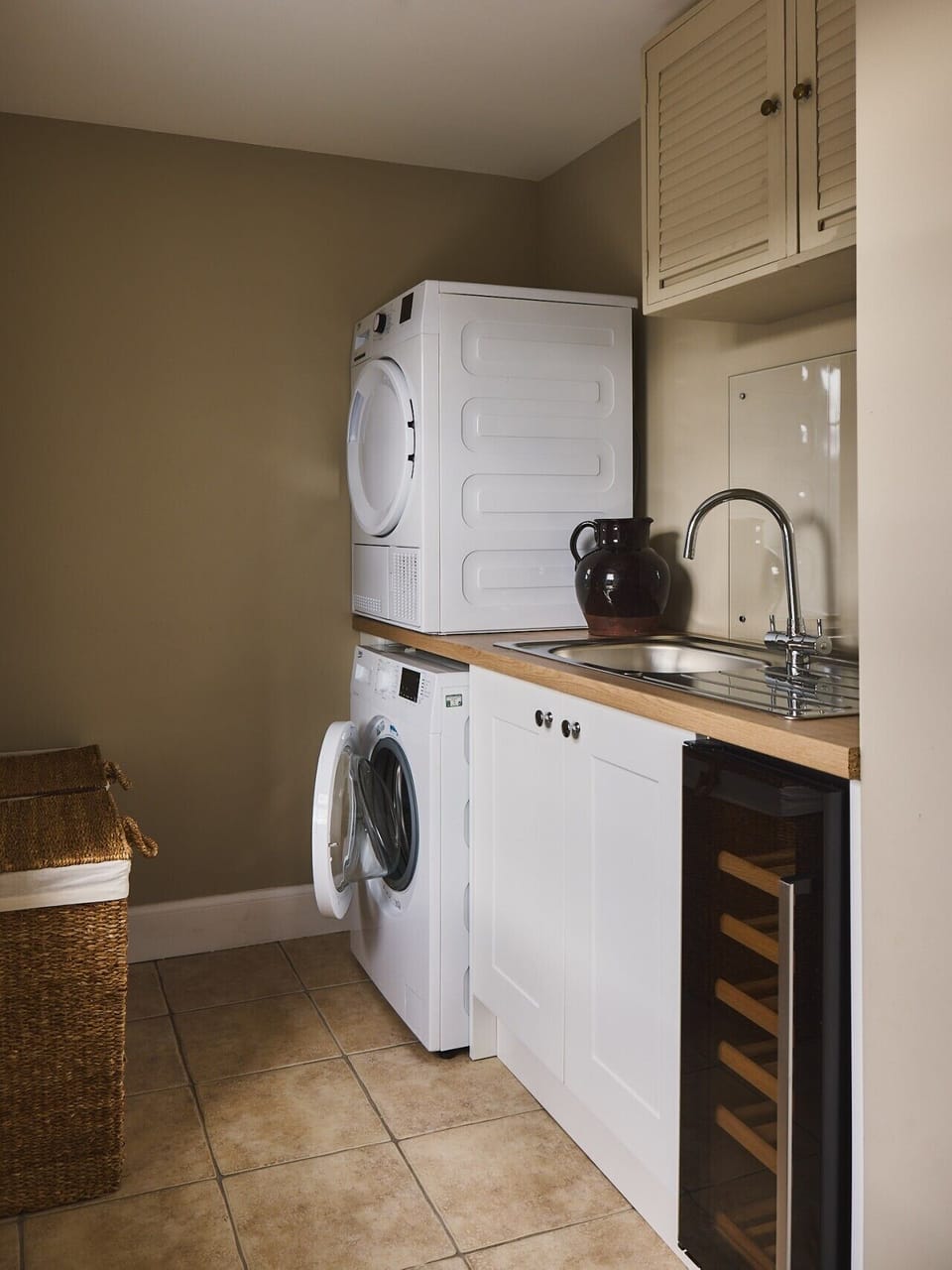Downstairs laundry with a washing machine and a dryer and a wine fridge