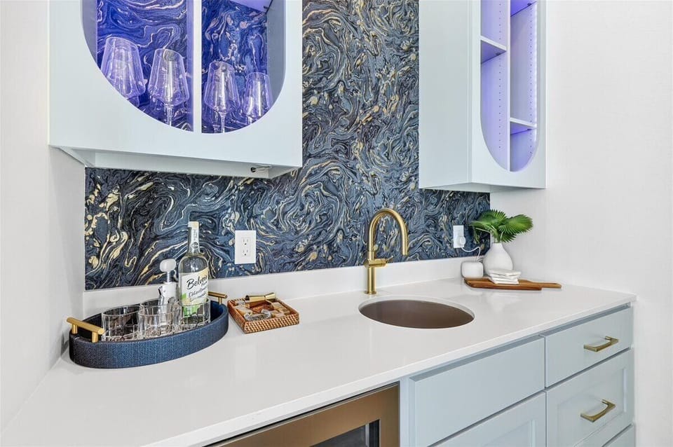 Second floor wet bar - Featuring custom cabinetry, elegant countertops, and ambient lighting, this stylish wet bar offers open shelving for glassware and spirits, plus a built-in beverage refrigerator for effortless entertaining.