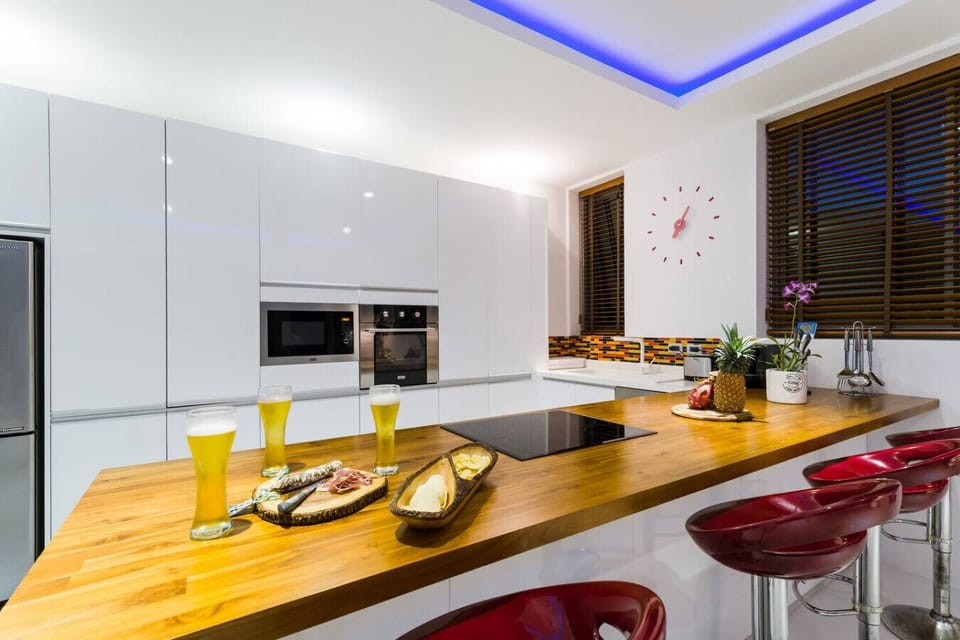 A fully equipped gourmet kitchen featuring premium modern appliances, sleek cabinetry, and a clean minimalist aesthetic
