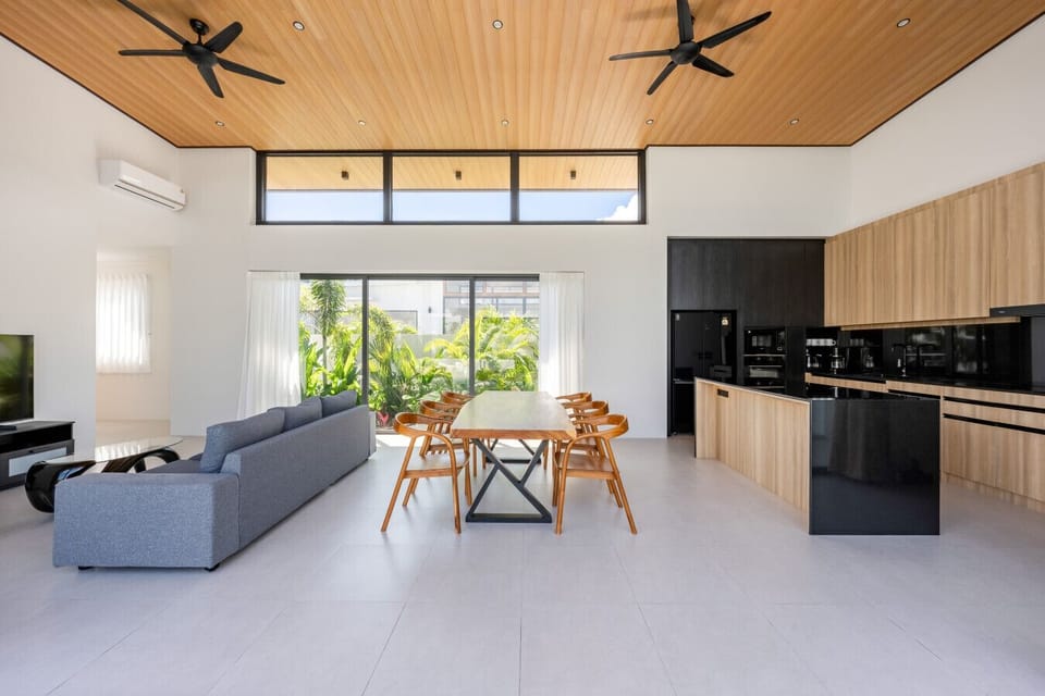 Sophisticated dining zone with premium wood table, seating for large groups, and stunning indoor-outdoor connection