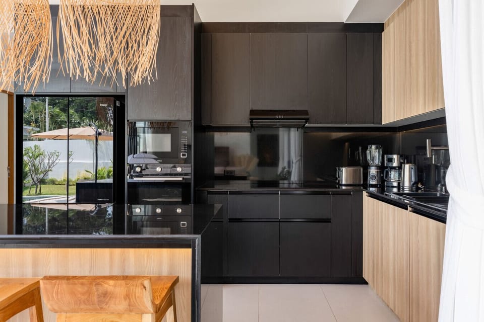 Fully equipped modern kitchen with sleek dark cabinetry in Elysium Villa, Koh Samui
