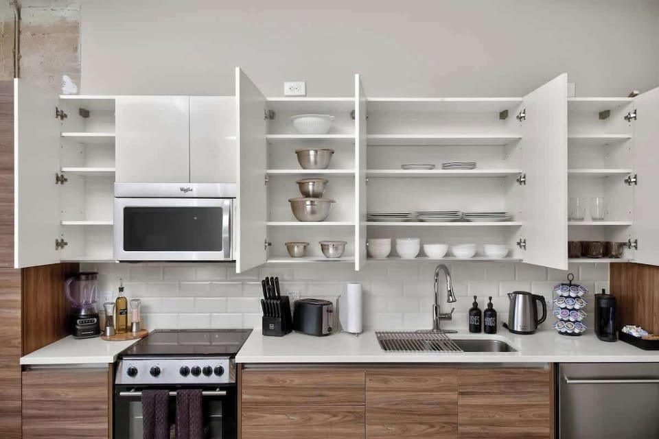 Fully stocked kitchen with everything groups of 12 need - cookware, appliances, and organized storage in downtown Dallas loft.