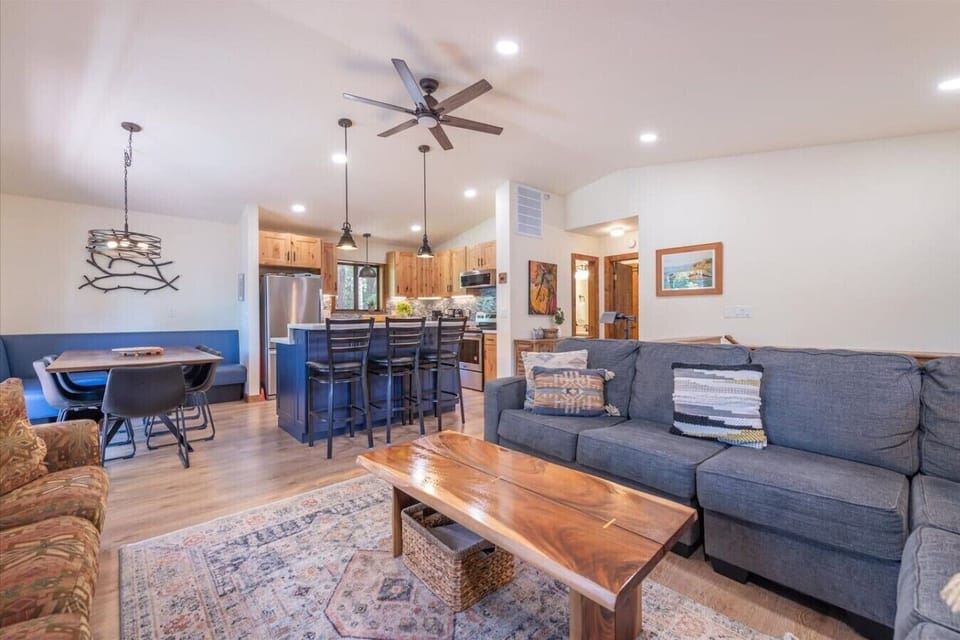 Spacious great room with vaulted ceilings, living area, gas fireplace, 50 inch SmartTV, dining area, kitchen and direct access to front deck.