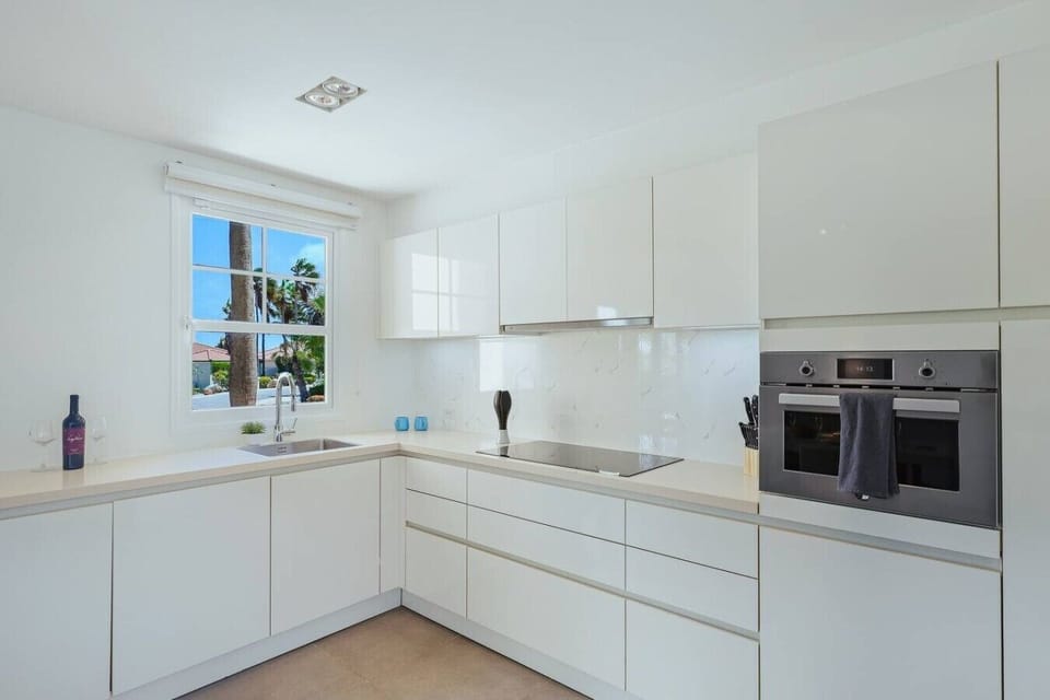 Fully equipped kitchen featuring modern appliances, cookware, essentials, and ample space for meal preparation.