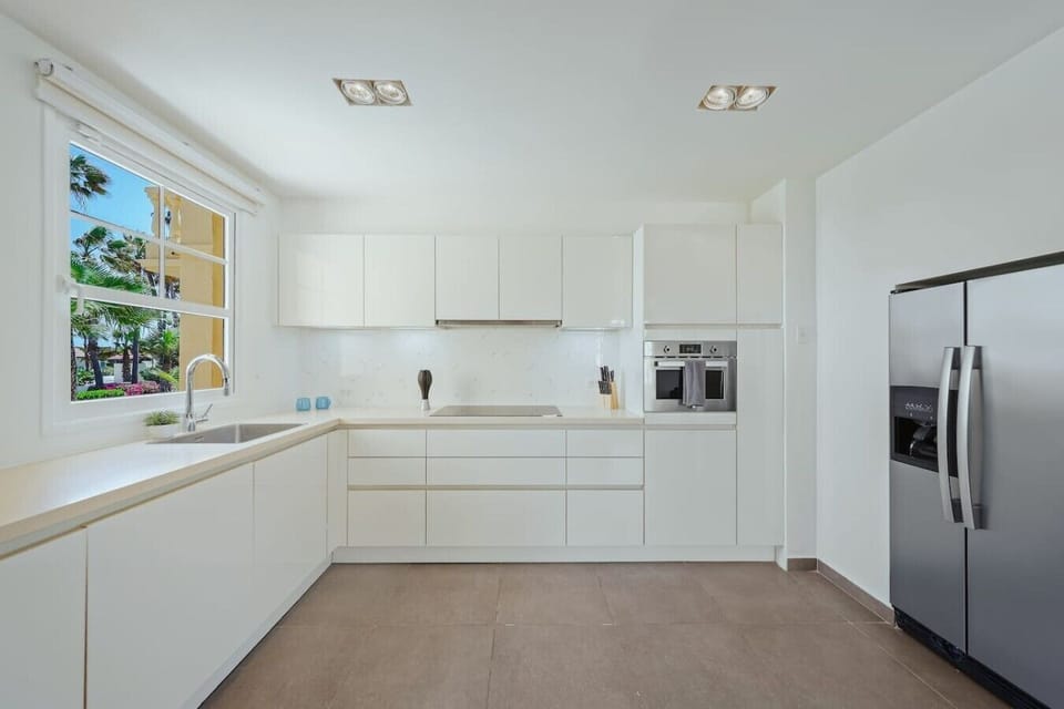 Fully equipped kitchen featuring modern appliances, cookware, essentials, and ample space for meal preparation.