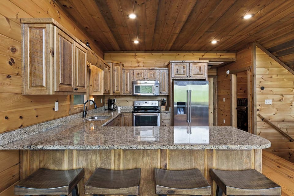  Everything you need to cook, gather & enjoy meals together! This gorgeous cabin kitchen features granite counters, full-size appliances & a large breakfast bar — so you can skip the restaurant & savor every moment in.