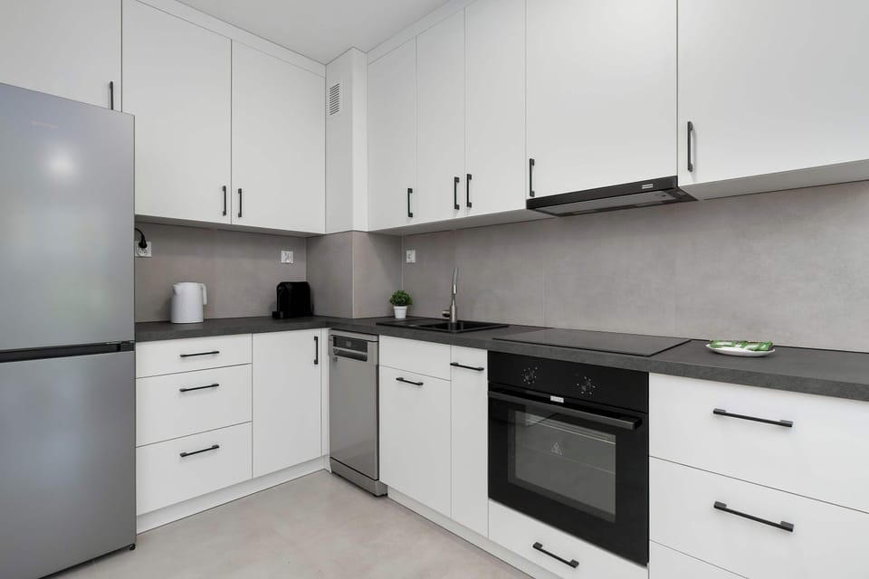 Another view of the kitchen showing a refrigerator and countertop workspace. The layout is compact but well-organized with plenty of storage.