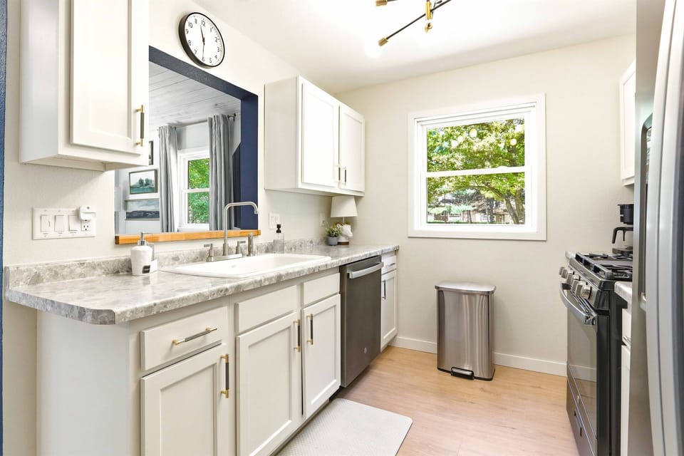 Cook with ease in a bright, refreshed kitchen featuring modern finishes and peaceful views of the trees.