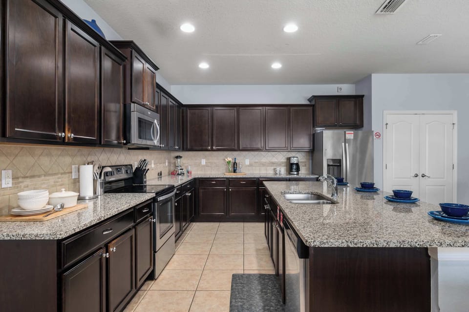 Spacious kitchen w/ dark cabinetry, ample counter space & room to cook for a crowd.
