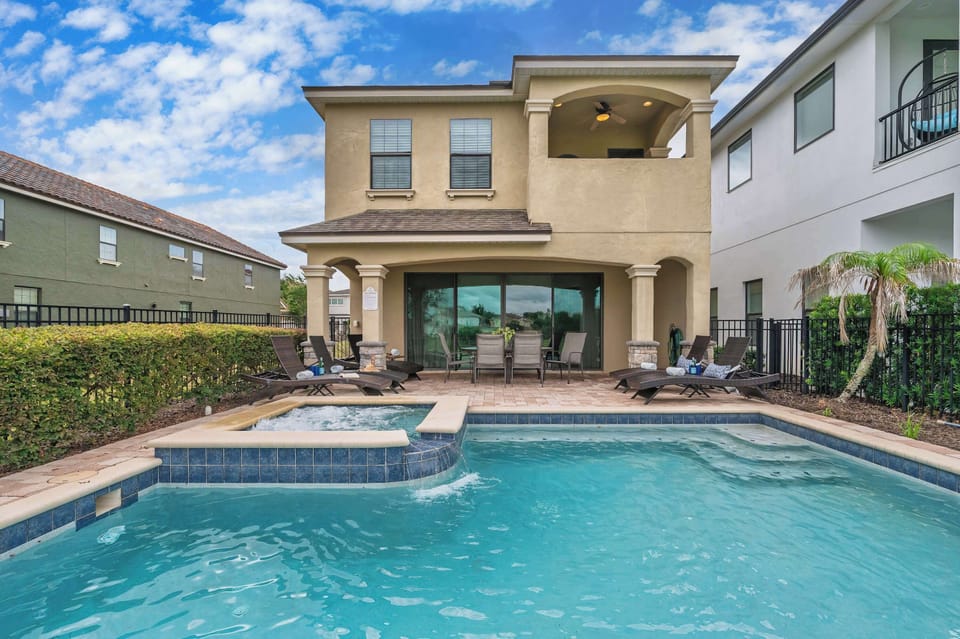 Relax by the private pool and spa at this modern two-story home with covered patio seating.