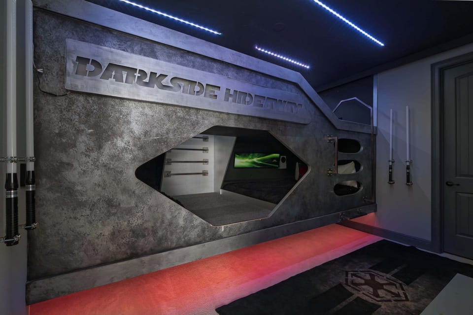 Modern themed bunk bed area with built-in lighting and a gaming setup for a unique stay experience.