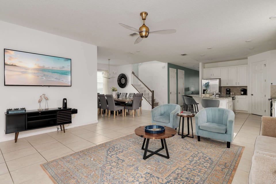 Open-concept living and dining area with modern furnishings and a ceiling fan.