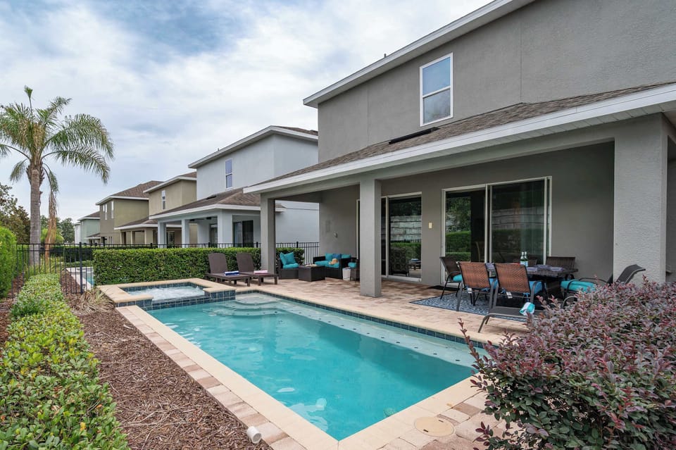 Modern backyard with a pool, hot tub, and covered patio seating area.