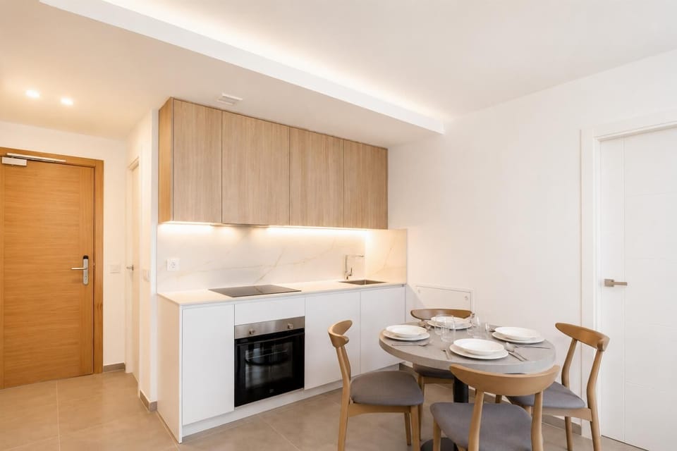 A modern kitchen and dining area with warm wooden cabinetry and elegant neutral decor.
