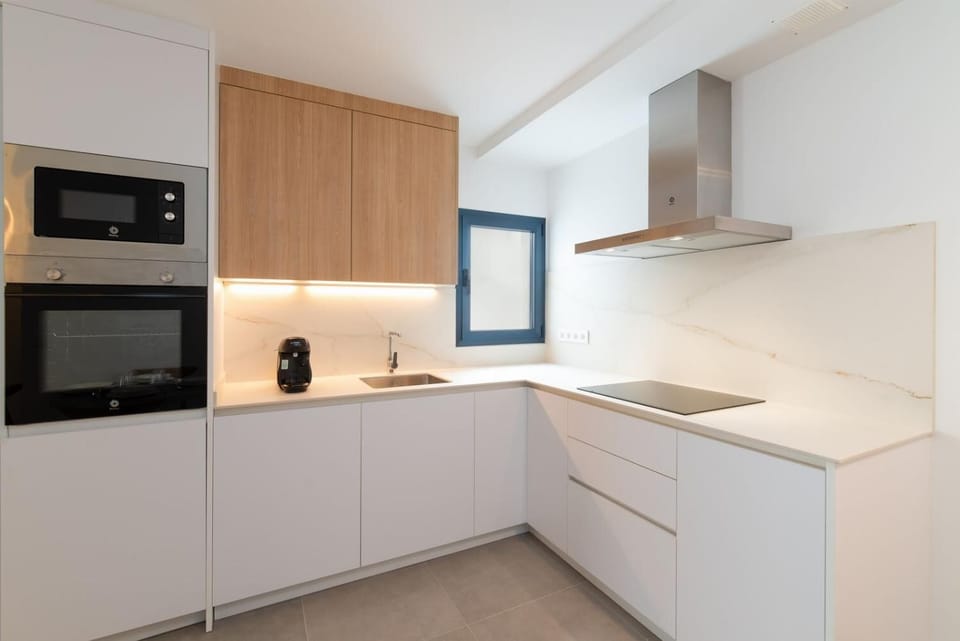 A modern kitchen and dining area with warm wooden cabinetry and elegant neutral decor.