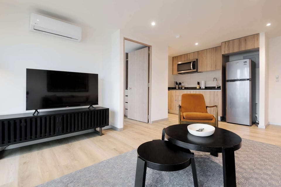 Inviting living room with floor-to-ceiling windows and a TV, creating the perfect space to relax.