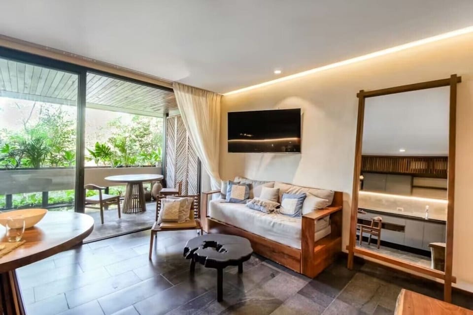 Bright and stylish living space with cozy modern décor, Smart TV, and seamless indoor-outdoor vibes perfect for relaxing after a beach day.