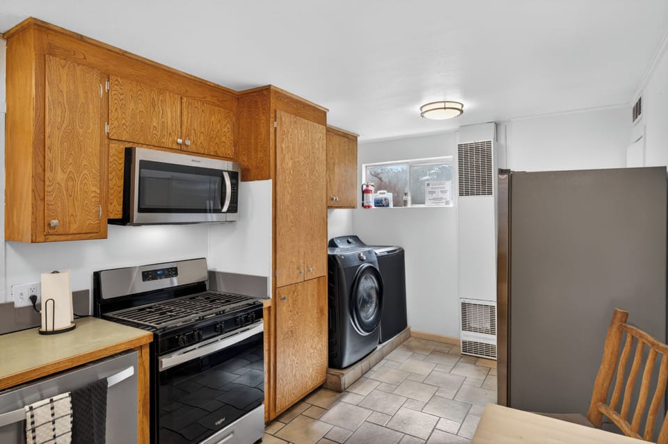 The well-equipped kitchen features a gas range and warm wood cabinetry, plus the added convenience of an in-unit washer and dryer right at hand to keep your adventure gear fresh.