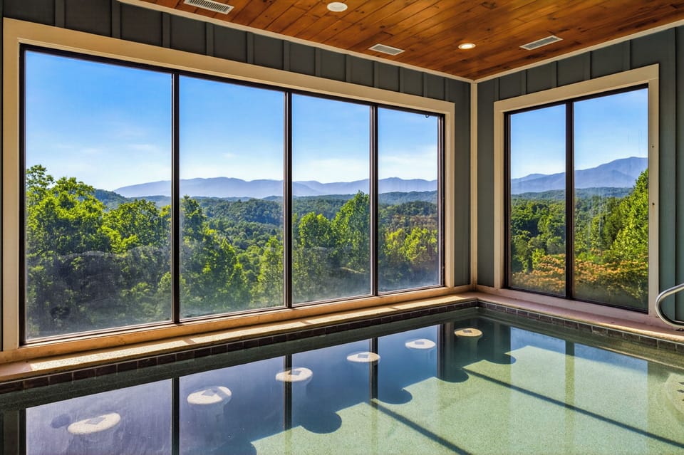 Spacious indoor swimming pool room with scenic Smoky Mountain views and relaxing private resort-style atmosphere.