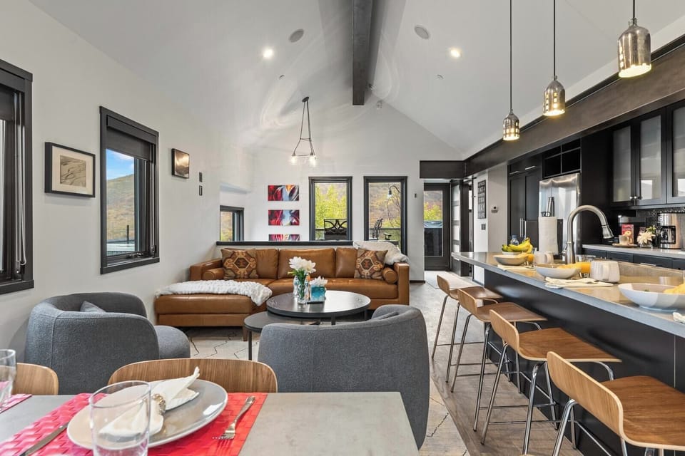 Open-concept living area with vaulted ceilings and stylish furnishings brings everyone together in one bright space. PEA-1114