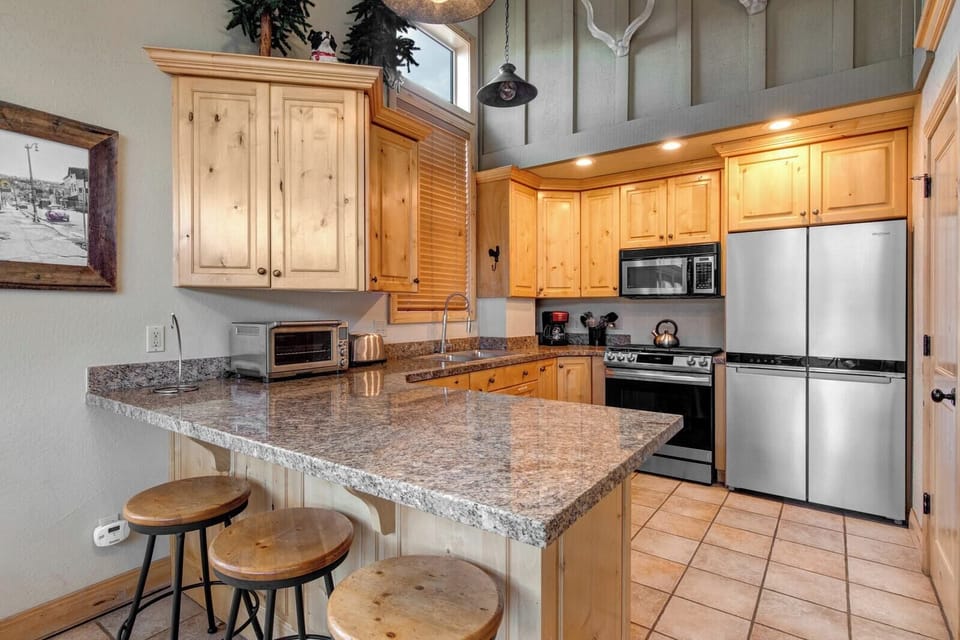 Cook with ease in your fully equipped kitchen featuring granite countertops, stainless appliances, and bar seating for casual bites. PEA-1260
