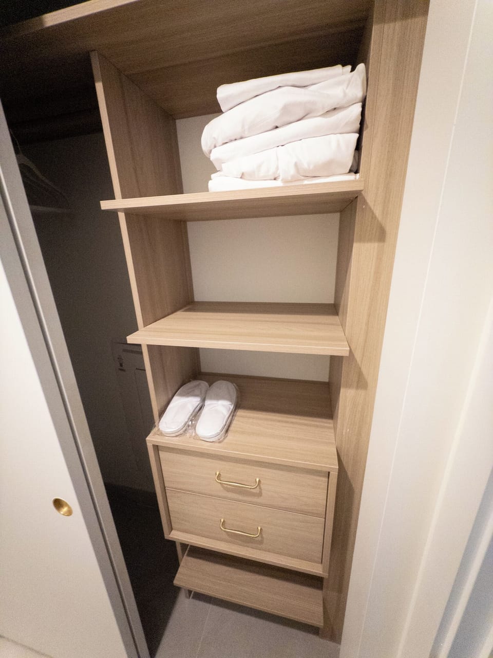 Spa-style touches - fresh towels and robes stocked on custom shelving, hotel-ready.