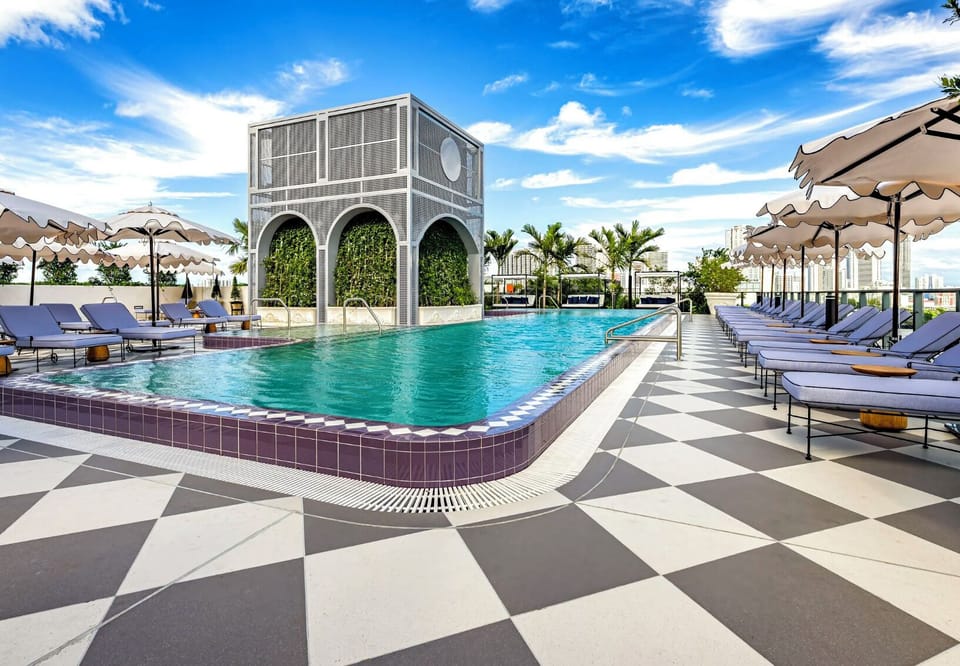 A resort-style pool deck with private cabanas, arched architecture and a graphic stone terrace - your escape steps from home.