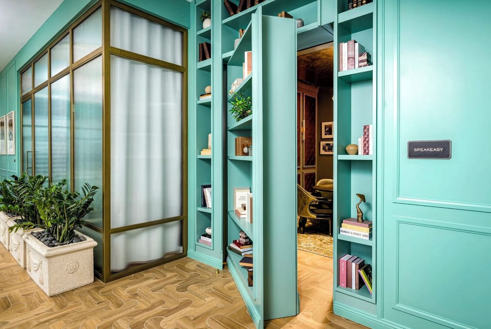 A handsome library and wine nook in deep-green cabinetry - a quiet corner to work or share a glass after hours.