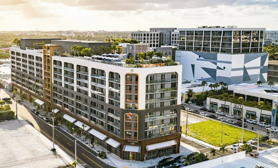 Aerial perspective of the residences and their lushly landscaped courtyard, framed by the Miami skyline.