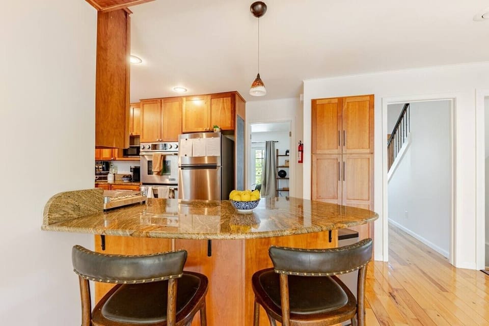 You said: listing captionThis bright, open-concept kitchen features warm wood cabinetry, stainless steel appliances, and a unique curved granite island with raised breakfast bar seating, perfect for casual dining or entertaining. The space seamlessly conn