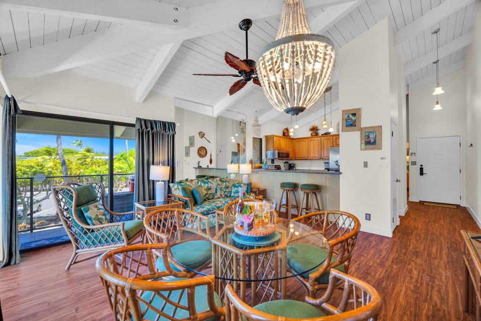 Open-concept layout with vaulted ceilings, stylish chandelier, and seamless flow from kitchen to lanai—ideal for entertaining. NAP-C37