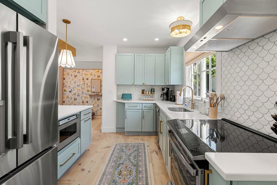 Coastal blue cabinetry and scalloped backsplash bring seaside charm
