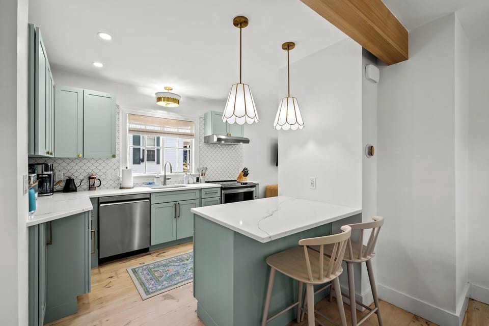 Renovated kitchen with quartz counters, coffee station, and peninsula seating