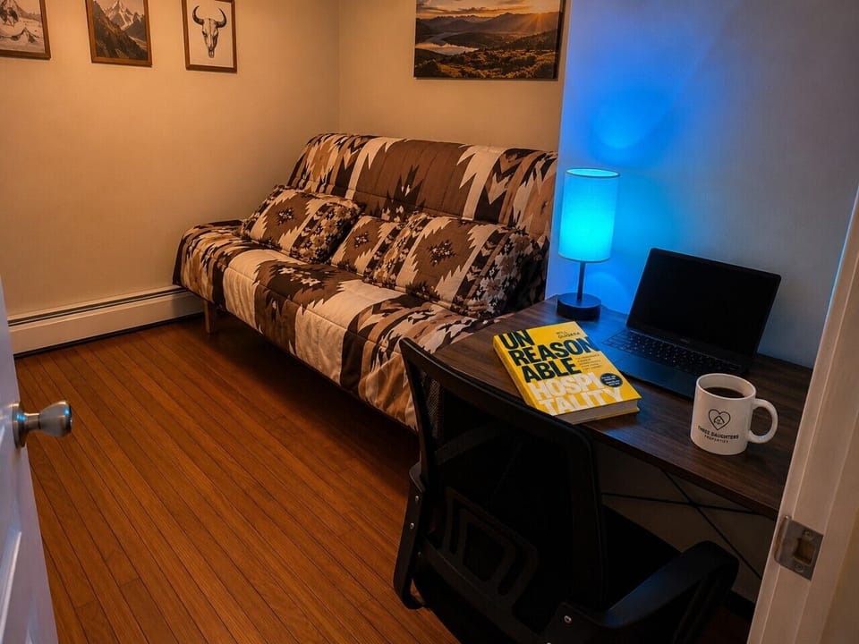 Additional sleeping space with a queen futon, desk setup, and cozy lighting for flexible group stays. 🛋️💻