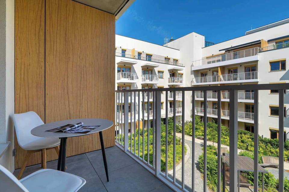 Private balcony with outdoor seating and views of the inner courtyard.