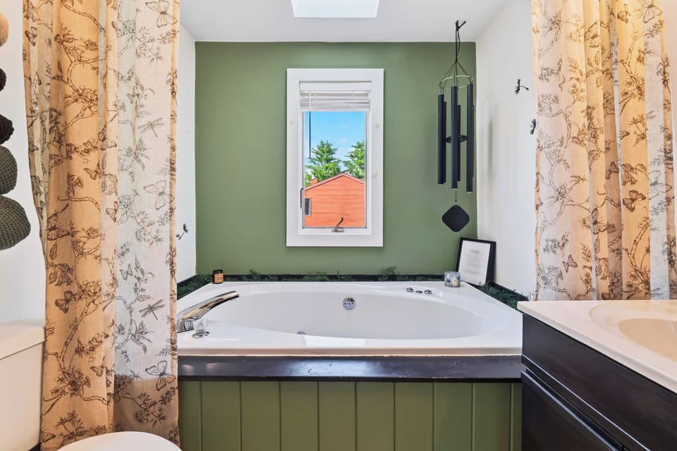 The full bathroom features a shower and a jetted tub.